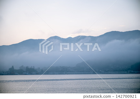 六月初的一個清晨,濃厚的晨霧靜靜地籠罩山坡,營造出寧靜的海濱景色。 六月初的一個清晨,濃厚的晨霧靜靜地籠罩山坡,營造出寧靜的海濱景色。 142700921