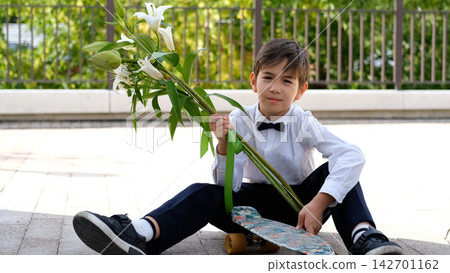Schoolboy with Flowers and Skateboard on September 1, First Day of School, Back to School, Knowledge Day, Modern Student and School Life Schoolboy with Flowers and Skateboard on September 1, First Day of School, Back to School, Knowledge Day, Modern Student and School Life 142701162