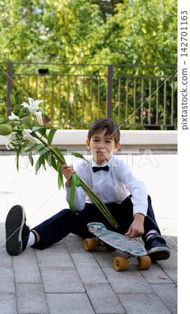 Schoolboy with Flowers and Skateboard on September 1, First Day of School, Back to School, Knowledge Day, Modern Student and School Life Schoolboy with Flowers and Skateboard on September 1, First Day of School, Back to School, Knowledge Day, Modern Student and School Life 142701163