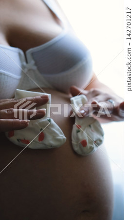Pregnant Belly with Tiny Baby Socks, Expecting a Newborn, Pregnancy Announcement, Motherhood and Baby on the Way Pregnant Belly with Tiny Baby Socks, Expecting a Newborn, Pregnancy Announcement, Motherhood and Baby on the Way 142701217