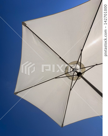 Low angle shot of white beach umbrella against clear blue sky with copy space  142701800