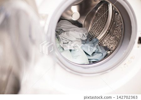 Washing machine drum loaded with clothes for laundry Washing machine drum loaded with clothes for laundry 142702363