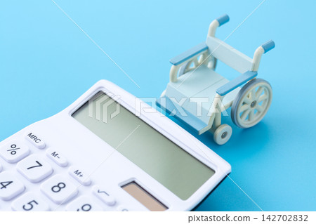 一台白色計算器和一輛輪椅 一台白色計算器和一輛輪椅 142702832
