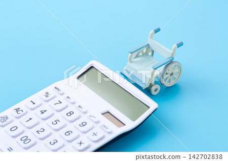 A white calculator and a wheelchair A white calculator and a wheelchair 142702838