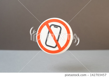 A symbol prohibiting mobile phone use. Turn off phones, maintain secrecy and focus at work. Concept of workplace discipline and confidential business meetings today. A symbol prohibiting mobile phone use. Turn off phones, maintain secrecy and focus at work. Concept of workplace discipline and confidential business meetings today. 142703457