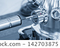 Close-up of a touch probe measuring an aluminum part in a blue tone scene 142703875