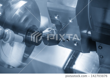 Close-up of a CNC lathe face cutting a metal ring part in a blue tone scene Close-up of a CNC lathe face cutting a metal ring part in a blue tone scene 142703876