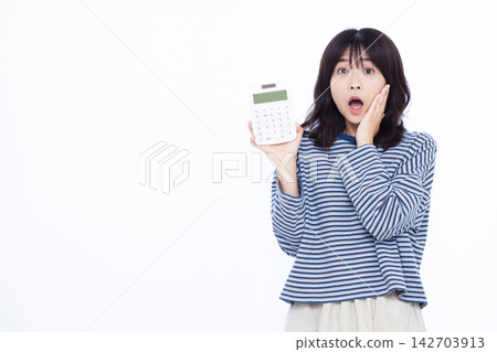 一位女士拿著計算器，臉上露出驚訝的表情。 142703913