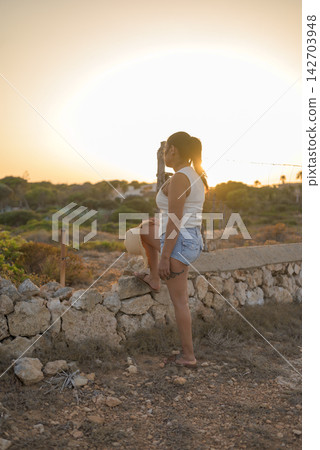 Latina Woman Contemplating Sunset in Rural Landscape Latina Woman Contemplating Sunset in Rural Landscape 142703948