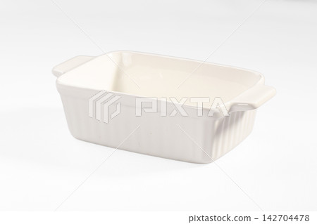 Empty white ceramic baking dish with ribbed sides and handles on clean white background Empty white ceramic baking dish with ribbed sides and handles on clean white background 142704478
