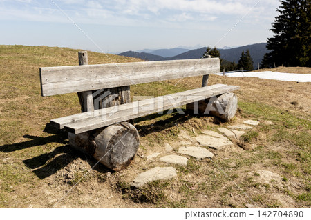 Bench at summmit cross of Rechelberg mountain in springtime, Bavaria, Germany Bench at summmit cross of Rechelberg mountain in springtime, Bavaria, Germany 142704890