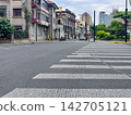 A Quiet Urban Scene Featuring a Crosswalk and Surrounding Architecture Amidst a Calm Overcast Day in a Busy City 142705121