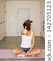 A Playful Moment Captured: Woman Wearing a Horse Mask Gives a Thumbs Up in a Quirky Indoor Setting 142705123