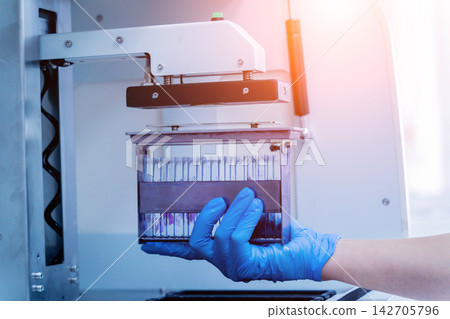 Laboratory assistant works with automatic multi slides stainer at the modern laboratory. Laboratory assistant works with automatic multi slides stainer at the modern laboratory. 142705796