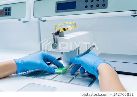 Laboratory assistant works at paraffin wax dispenser tissue embedding machine. Laboratory assistant works at paraffin wax dispenser tissue embedding machine. 142705831