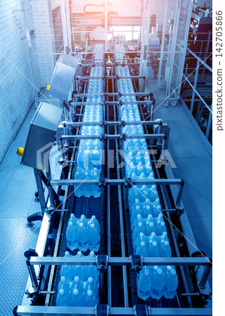 Modern strapping and transporting machine for packaging line at beverage plant. Modern strapping and transporting machine for packaging line at beverage plant. 142705866
