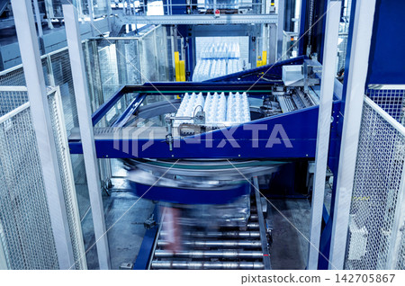 Modern strapping and transporting machine for packaging line at beverage plant. 142705867