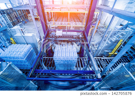 Modern strapping and transporting machine for packaging line at beverage plant. Modern strapping and transporting machine for packaging line at beverage plant. 142705876