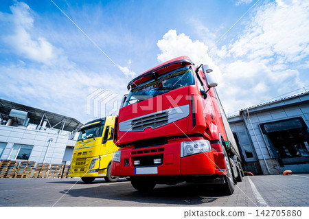 Large trucks near warehouse against blue sky background Large trucks near warehouse against blue sky background 142705880