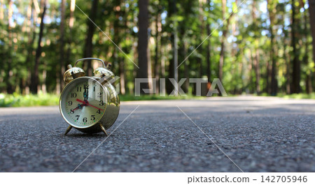 Vintage Bell Arrows Clock On A Blurred Walking Way With Benches In Park Zone Vintage Bell Arrows Clock On A Blurred Walking Way With Benches In Park Zone 142705946