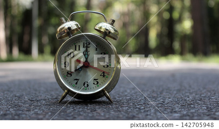 Classic Bell Clock On Asphalt Walk Path At City Park. Time For A Morning Jog In The Park At 8AM Classic Bell Clock On Asphalt Walk Path At City Park. Time For A Morning Jog In The Park At 8AM 142705948