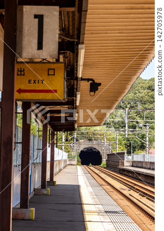 Title: A scene of a train station platform with an exit sign and the number 1 displayed, photographed at eye level. Title: A scene of a train station platform with an exit sign and the number 1 displayed, photographed at eye level. 142705978