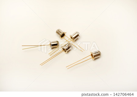 Metal photodiodes on a white background. Phototransistors. Yellow semiconductor devices. Metal photodiodes on a white background. Phototransistors. Yellow semiconductor devices. 142706464