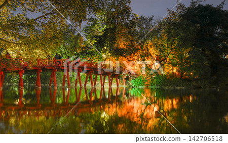 Hanoi, Vietnam: The Huc Bridge with illuminations at night. This bridge crosses Hoan Kiem Lake to the island where Ngoc Son Temple stands. Hanoi, Vietnam: The Huc Bridge with illuminations at night. This bridge crosses Hoan Kiem Lake to the island where Ngoc Son Temple stands. 142706518