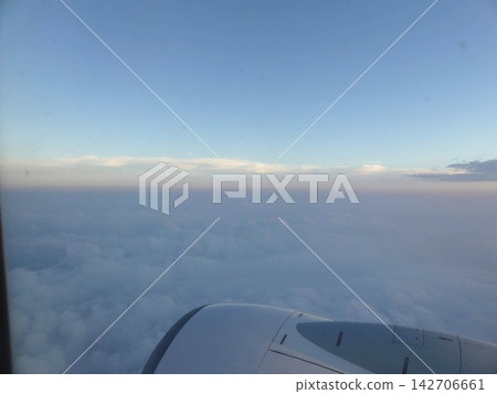 從飛機上看到的雲海和藍天;可以看到飛機引擎的壯麗天空景色。 從飛機上看到的雲海和藍天;可以看到飛機引擎的壯麗天空景色。 142706661