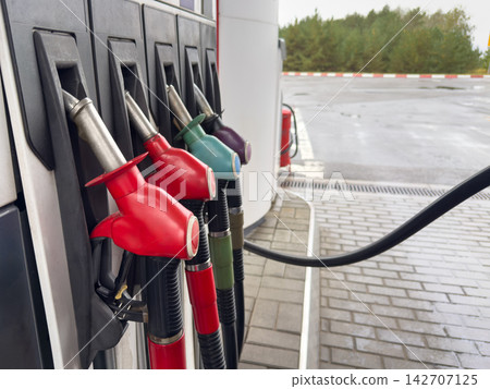 Fuel nozzles at gas station pump close up with selective focus Fuel nozzles at gas station pump close up with selective focus 142707125