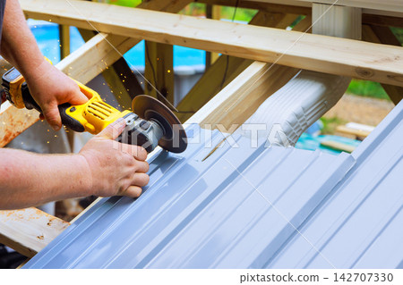 Man uses tool to cut metal panels on construction site Man uses tool to cut metal panels on construction site 142707330