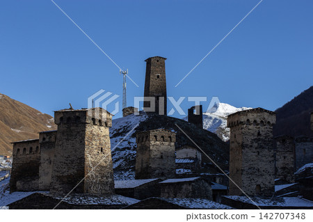 Medieval Svan Towers in Ushguli Village Against Snowy Mountains and Blue Sky Medieval Svan Towers in Ushguli Village Against Snowy Mountains and Blue Sky 142707348