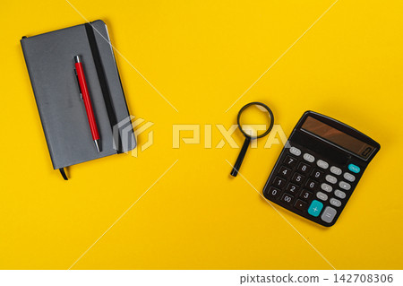 Tools for finance planning on a bright yellow surface Tools for finance planning on a bright yellow surface 142708306