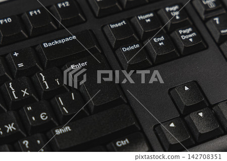 Black keyboard close-up in modern office workspace setting Black keyboard close-up in modern office workspace setting 142708351