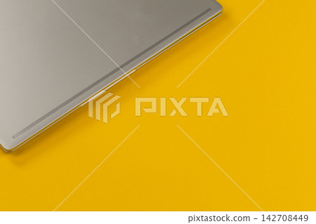 Laptop resting on a bright yellow surface in a modern workspace 142708449