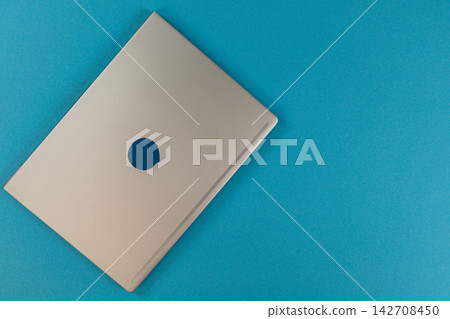 Laptop rests on a bright blue desk in a modern workspace Laptop rests on a bright blue desk in a modern workspace 142708450