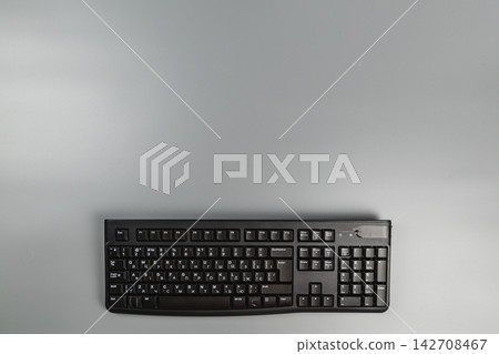 Modern computer keyboard on grey desk surface in office workspace Modern computer keyboard on grey desk surface in office workspace 142708467