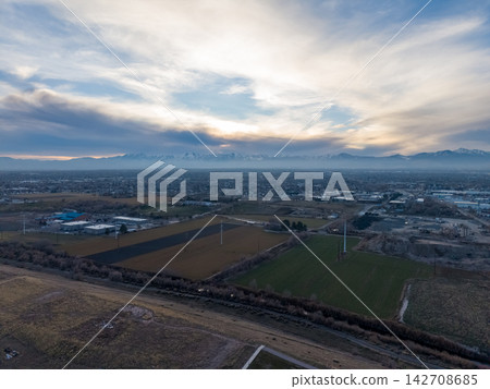 Aerial view of agricultural fields and distant snow capped mountains 142708685
