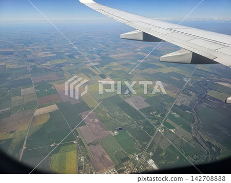 Airplane Wing Above Farmland and Winding Water Channels in Argentina Airplane Wing Above Farmland and Winding Water Channels in Argentina 142708888