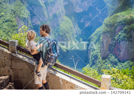 Father with two sons admiring Sumidero Canyon and the river below in Chiapas Mexico with steep canyon walls lush landscape river overlook nature tourism and walking near the viewpoint. 142709141