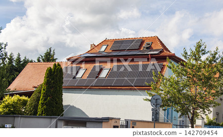 Residential Building with Extensive Rooftop Solar Panel Installation 142709454