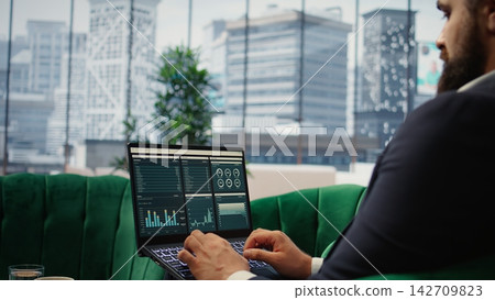 Determined CEO works in office analyzing infographics and setting business goals to drive corporate growth, global investment strategy in a competitive environment. Leadership skills. Camera A. 142709823