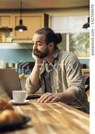 Bored indifferent man, using laptop with low energy, hopeless dejected adult, lack of motivation and discontent. Demotivated freelancer, tired of work, discontent and lazy. Disengagement. Bored indifferent man, using laptop with low energy, hopeless dejected adult, lack of motivation and discontent. Demotivated freelancer, tired of work, discontent and lazy. Disengagement. 142709976