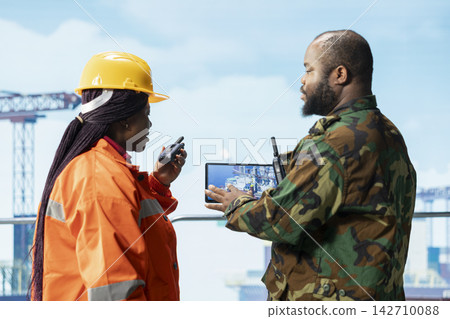 Soldier present on offshore rig to deter insurgent attacks using device to visualize infrastructure. Naval unit on drilling barge under maritime interdiction protocol uses tablet to make security plan 142710088