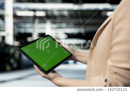 Green screen tablet used by data center technician typing on display, doing gear upgrades. Mockup device application used by server farm employee to oversee operations and resource allocation, closeup Green screen tablet used by data center technician typing on display, doing gear upgrades. Mockup device application used by server farm employee to oversee operations and resource allocation, closeup 142710123