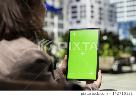 Green screen mockup tablet, reading digital book and woman enjoying morning in city outdoors. Relaxing outside, chroma key mockup ebook reader close up and person on park bench during sunny day Green screen mockup tablet, reading digital book and woman enjoying morning in city outdoors. Relaxing outside, chroma key mockup ebook reader close up and person on park bench during sunny day 142710131