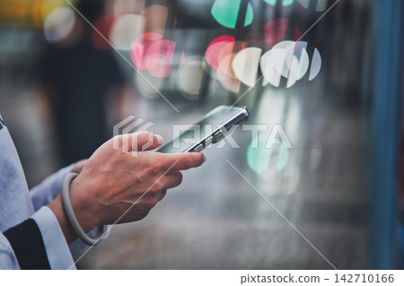 Hand of a woman holding a smartphone Hand of a woman holding a smartphone 142710166