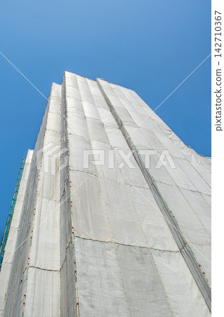 正在興建中的公寓大樓周圍已用防護網罩圍起。 142710367