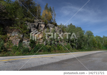 Scenic asphalt highway running along rocky cliff Scenic asphalt highway running along rocky cliff 142711721