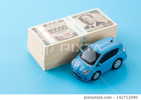 一輛藍色汽車和一疊500萬日元鈔票,背景是藍色的螢幕。 一輛藍色汽車和一疊500萬日元鈔票,背景是藍色的螢幕。 142712090